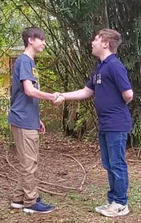 Chancellor Armstrong and Emperor Mevd shaking hands.